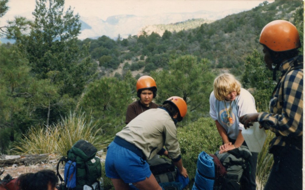 A group of teenage girls with backpacks and helmets on.