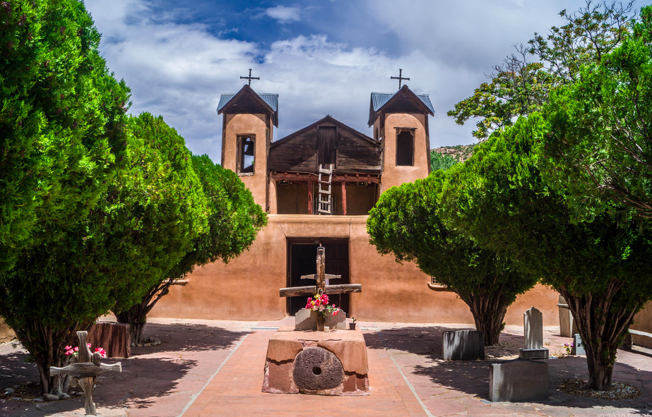 A church with trees and bushes in front of it