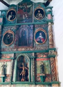 inside an old church with ceramic saints on the wall