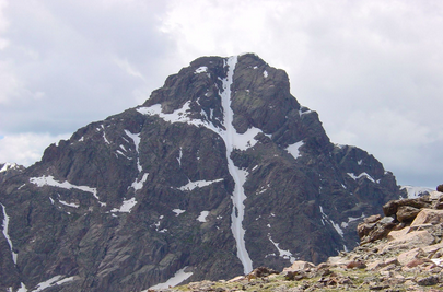 A mountain with snow on it's side.