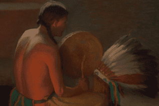 native american man sitting holding a drum