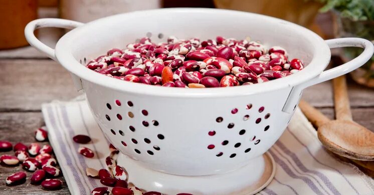 A white bowl filled with red beans on top of a table.