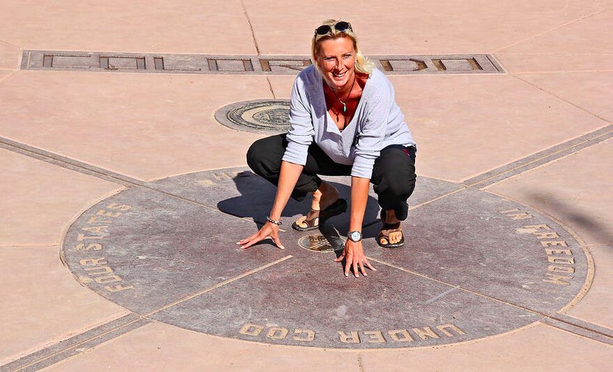 A woman kneeling down on the ground in front of a compass.