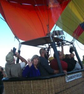 woman waving inside a hot air balloon